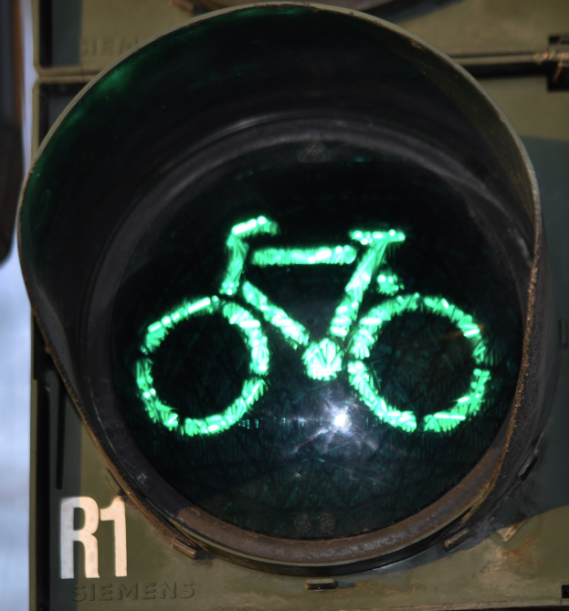 Grüne Ampel mit Fahrradsymbol, beleuchtet an einer Wand.