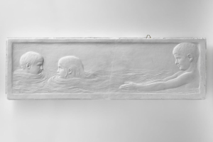 Drei Kinder schwimmen in einem Pool mit einer Wand im Hintergrund.