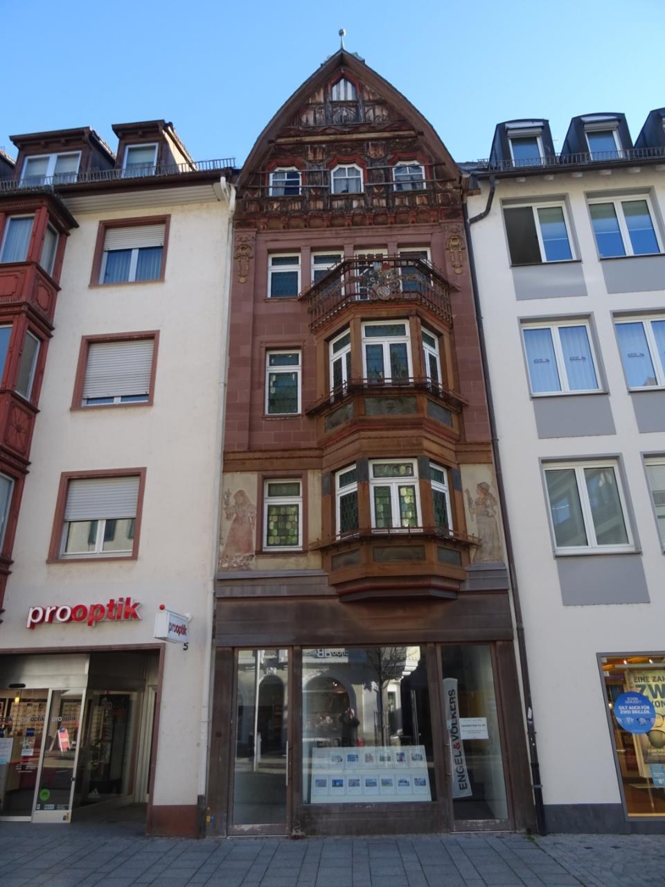 Gewerbestandort zum Verkauf in Heidelberg, Deutschland, mit einem mehrfenstrigen Gebäude neben einer Straße unter einem klaren blauen Himmel.