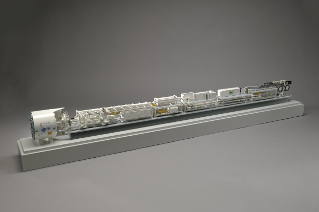 Detailiertes Modell eines Sainsbury's-Hydrogen-Brennstoffzellensystems auf einer weißen Oberfläche, das Komponenten wie einen Kraftstofftank, einen Filter und eine Einspritzdüse zeigt, die mit einer Stromquelle verbunden sind.