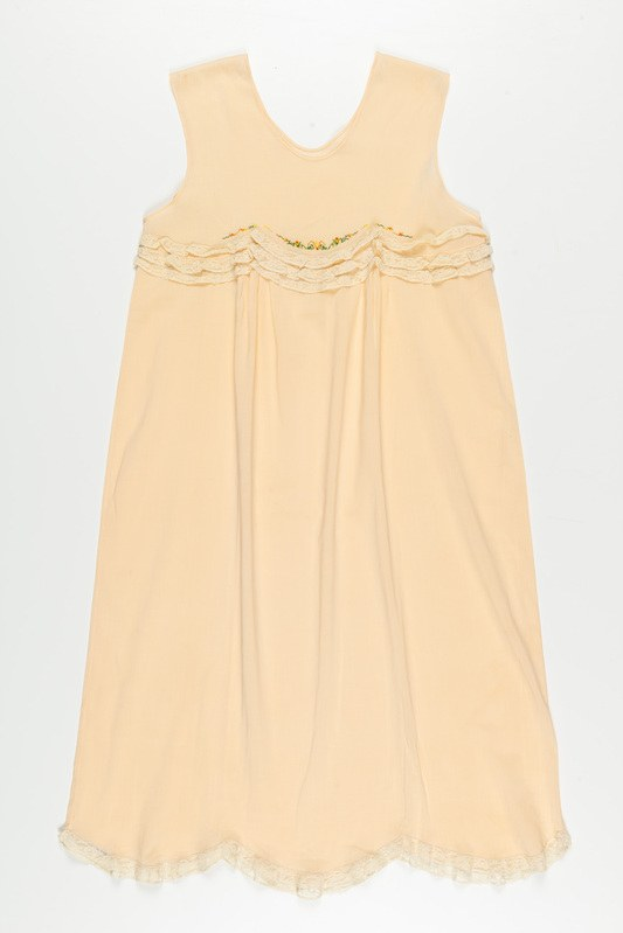 Ein cremefarbenes Nachthemd mit zarter Spitzenborte am Halsausschnitt, hergestellt aus weichem, leichtem Stoff mit einem dezenten Schimmer.