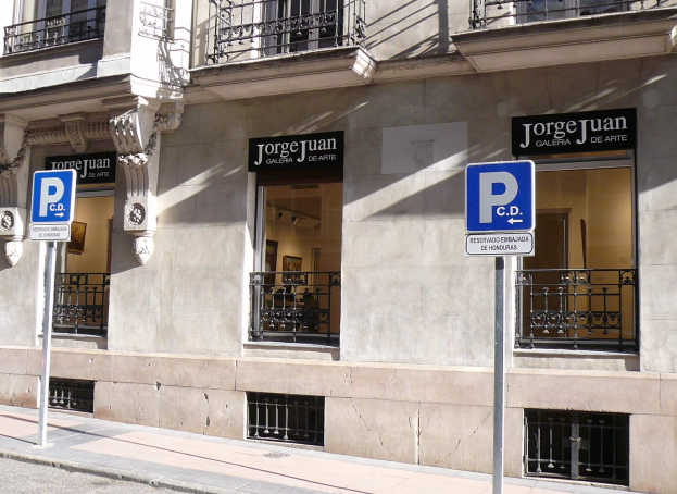 Ein mehrgeschossiges Gebäude mit Fenstern, Geländern, Türen und Säulen, das Werbetafeln auf Pfählen entlang des Gehwegs und sichtbare Innenobjekte aufweist, die auf eine belebte städtische Umgebung hinweisen.