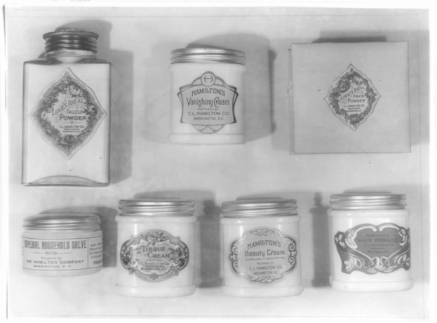 Schwarz-weiß-Foto eines Regals mit ordentlich angeordneten Töpfchen, die jeweils mit verschiedenen Arten beschriftet sind.