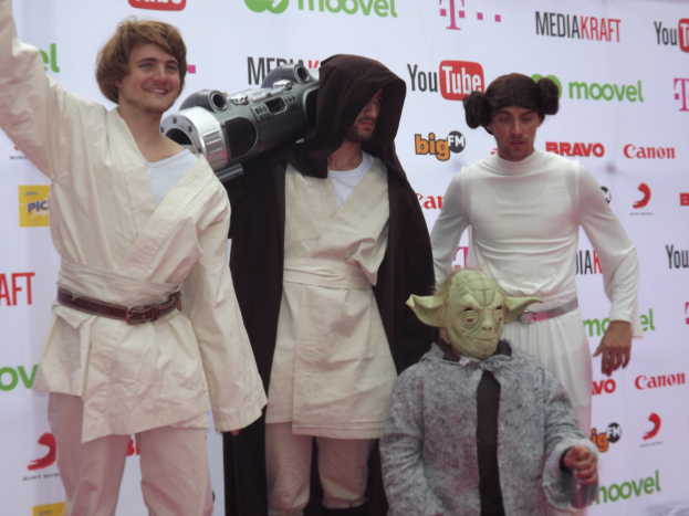 Gruppe von Menschen in Star-Wars-Kostümen, die auf einem roten Teppich posieren.