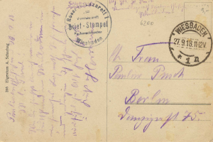 Alte Postkarte mit einem violetten Stempel, auf dem "Wiesbaden, Deutschland - 1. Weltkrieg" steht, und handgeschriebener Text.