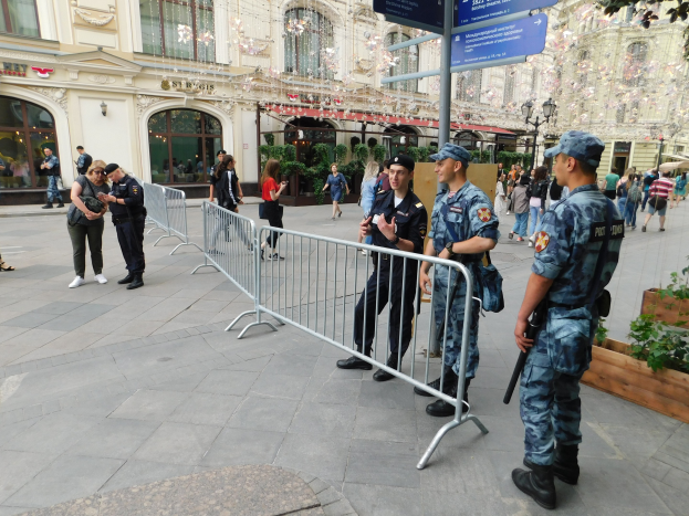 Polizeibeamte in Uniform stehen hinter Absperrungen und blicken einer Menge entgegen, einige halten Waffen, mit Schildern und Gebäuden im Hintergrund während einer Anti-Terror-Operation in Wien, Österreich.