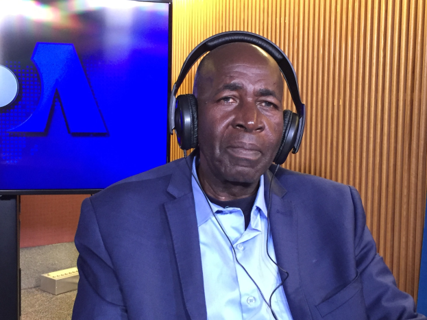 Ein Mann in Anzug und Kopfhörern sitzt vor einem Fernseher und spricht während einer Diskussion über das Verbot des Internets durch die nigerianische Regierung.