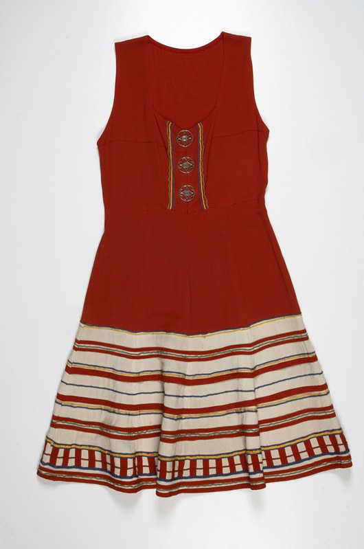 Ein leuchtend rotes Kleid mit weißen und gelben horizontalen Streifen vor einem weißen Hintergrund.