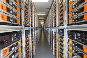 Eine lange Reihe von Servern in einem Datenzentrum mit elektronischen Geräten in den Racks und Lampen oben.