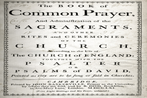 Ein abgenutztes, offenes Buch mit dem Titel "The Book of Common Prayer and Administration of the Sacraments, Rites and Ceremonies of the Church of England", das eine Seite mit schwarzer Tinte zeigt.