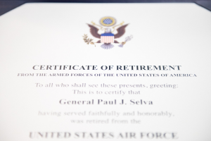 Ein gerahmtes Ruhestandszertifikat der US-Luftwaffe mit blauer Umrandung, das ein Schild-Logo mit einem zentralen Stern, einem Lorbeerkranz und einer schwarzen Schriftzeile "Ruhestand" zeigt.